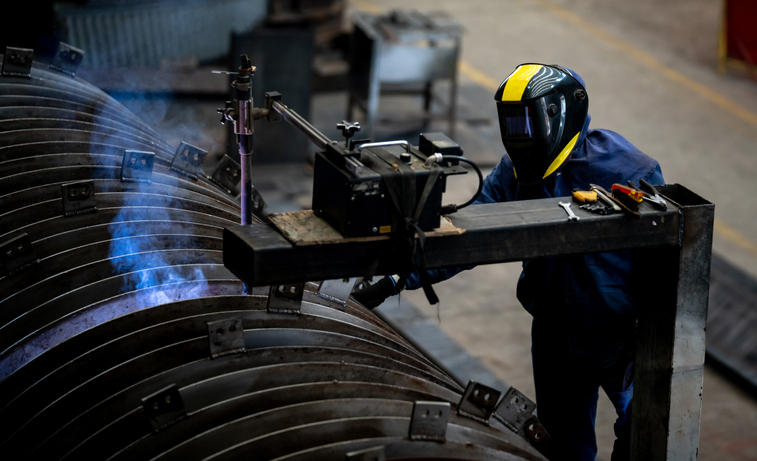 Operator welding on steel at a metallurgy factory - industry concepts
