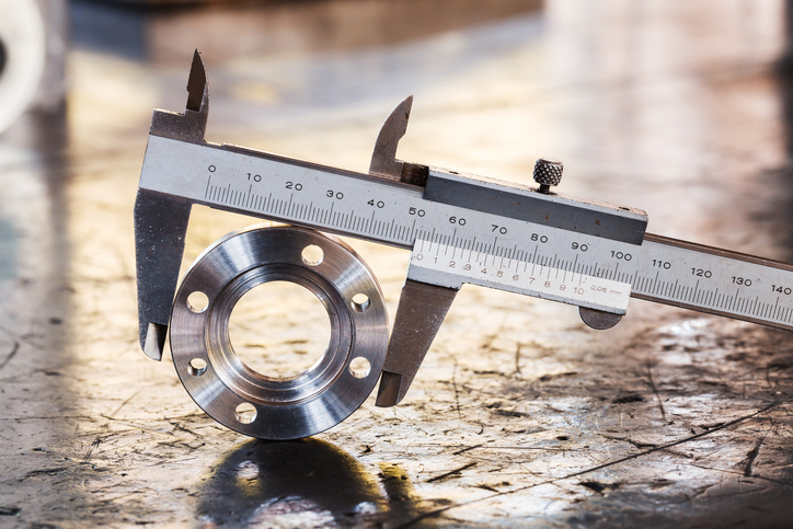 Close up vernier caliper measure diameter of stainless steel flange